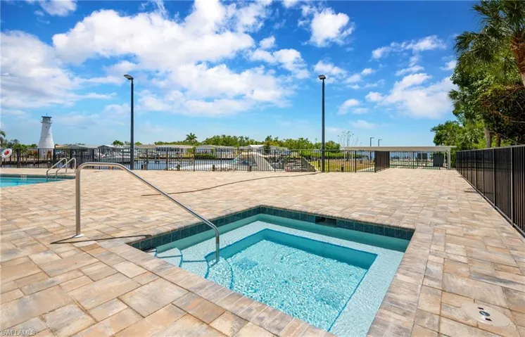 Community pool with a patio area and a hot tub