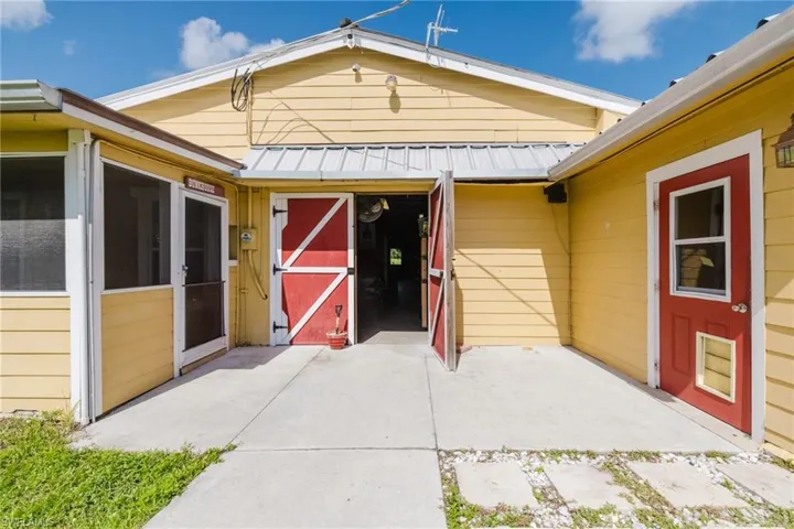 Yellow exterior siding with a metal roof and concrete patio
