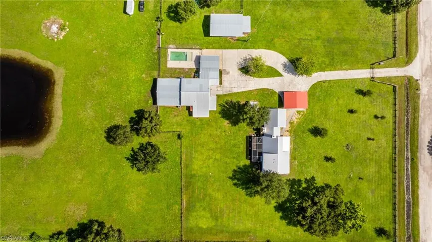 Expansive property featuring multiple structures, a private pond, and a swimming pool