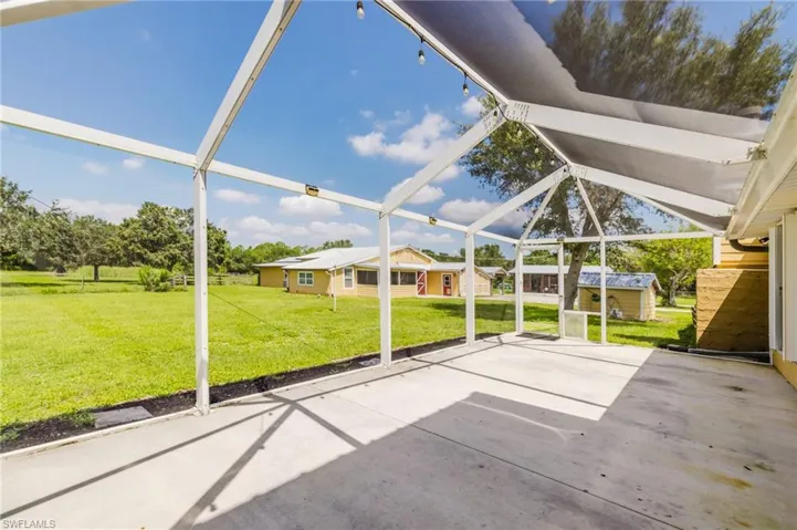 Expansive screened patio featuring a concrete surface and string lighting