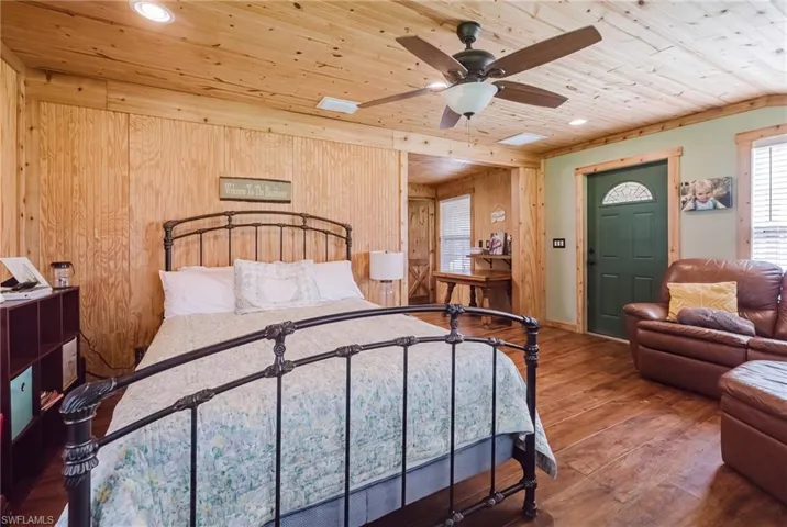 Wood-finish flooring throughout, with a wood-paneled ceiling and walls