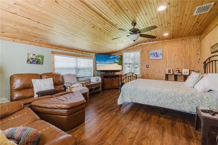 Wood-finish flooring throughout, featuring a wood plank ceiling and wood panel walls
