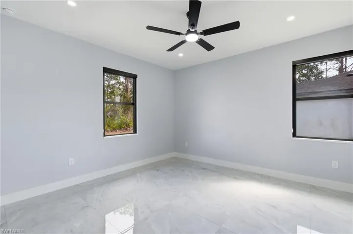 Unfurnished room featuring light marble finish floors, a ceiling fan, recessed lighting, and a smoke detector