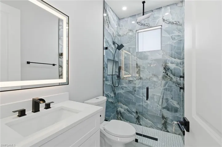 Full bathroom with a marble finish shower and vanity