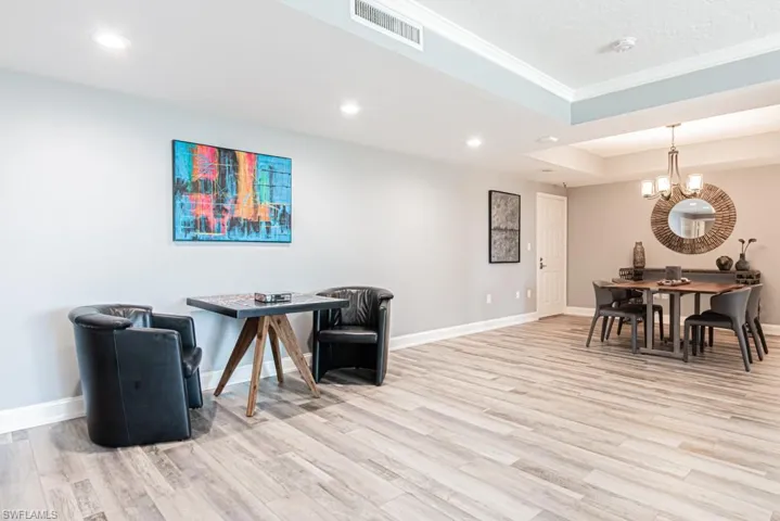 Office featuring light wood-style flooring, recessed lighting, a raised ceiling, a chandelier, and ornamental molding
