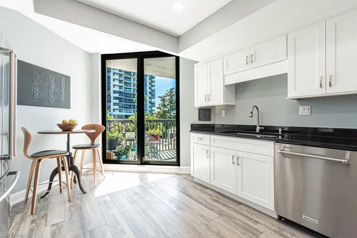 Kitchen featuring stainless steel appliances, white cabinets, light wood finished floors, floor to ceiling windows, and recessed lighting