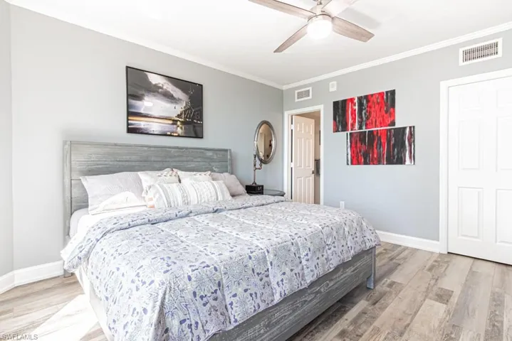 Bedroom featuring ornamental molding, ceiling fan, and light wood-style floors