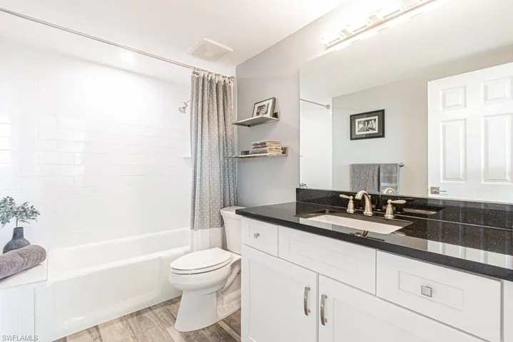 Full bathroom featuring shower / bath combo, light wood-type flooring, and vanity