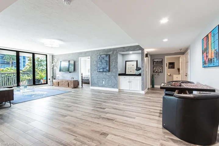 Living room featuring floor to ceiling windows, light wood-style vinyl floors, recessed lighting, and textured walls
