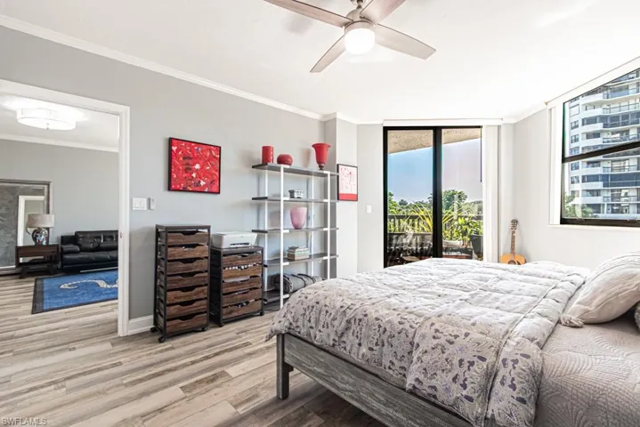 Bedroom featuring ornamental molding, access to outside, wood finished floors, a ceiling fan, and floor to ceiling windows