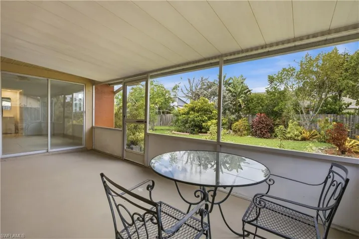 Screened patio with a covered ceiling, overlooking a lush, landscaped backyard