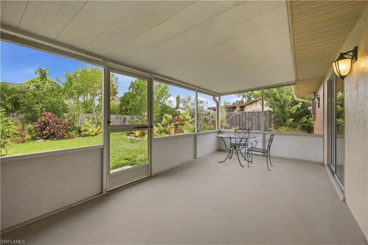 Screened patio with a concrete floor, white panel ceiling, and exterior wall sconce