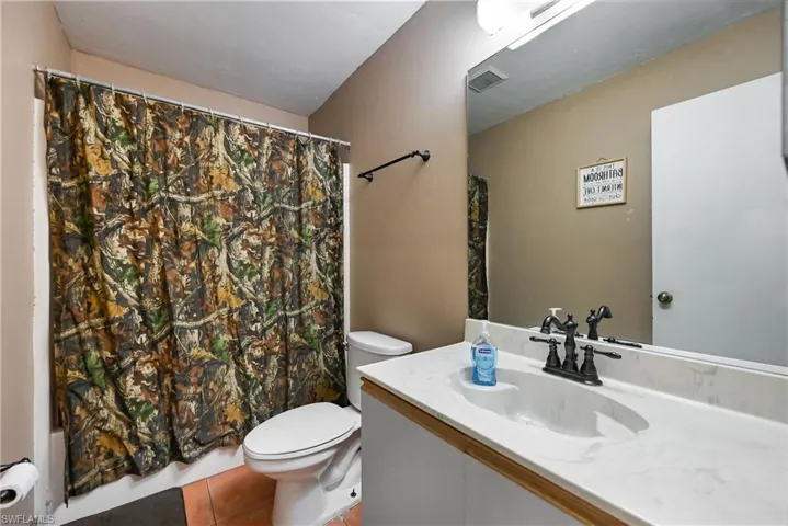 Full bath with vanity and light tile patterned floors