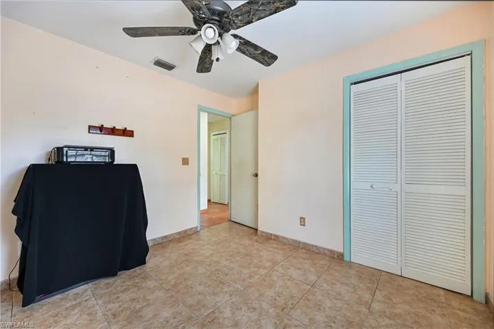 Unfurnished bedroom featuring ceiling fan, a closet, and light tile patterned flooring