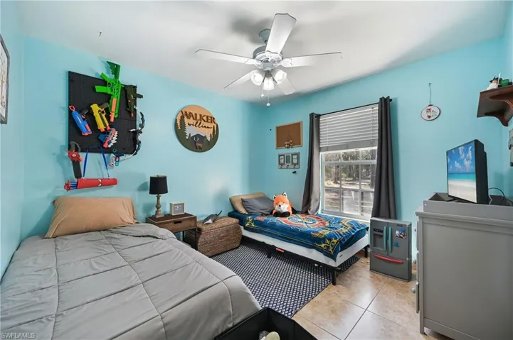 Bedroom with tile patterned floors and a ceiling fan