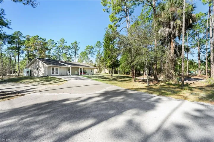 View of front of house featuring driveway and a front lawn