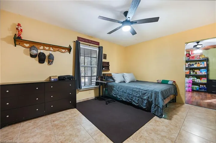 Bedroom with light tile patterned floors and a ceiling fan