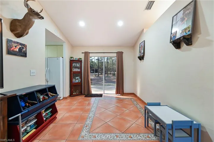 Doorway with inlaid floor details, tile patterned flooring, and recessed lighting