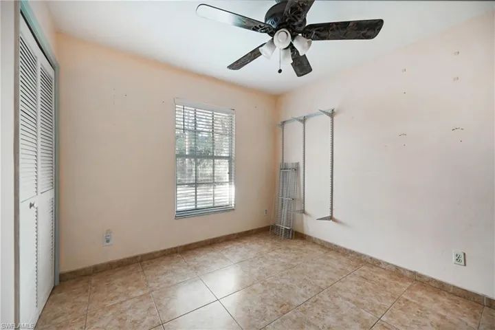 Unfurnished bedroom with a closet, ceiling fan, and light tile patterned floors