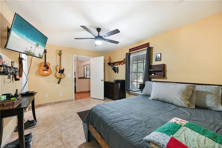 Bedroom with light tile patterned flooring and a ceiling fan
