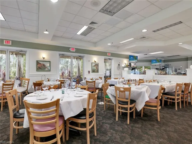 Dining space featuring a drop ceiling and dark colored carpet