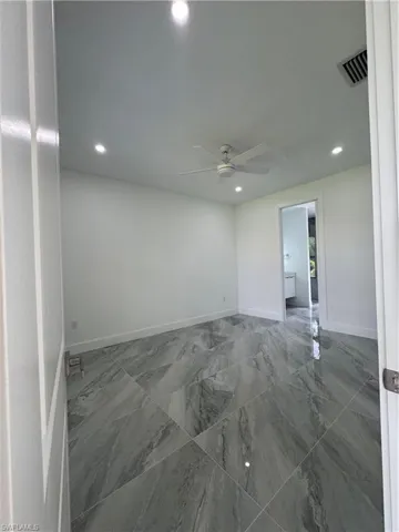 Unfurnished room featuring marble finish flooring, a ceiling fan, and recessed lighting