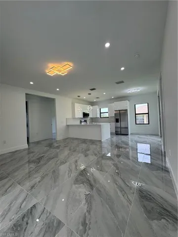 Unfurnished living room featuring recessed lighting and light marble finish flooring
