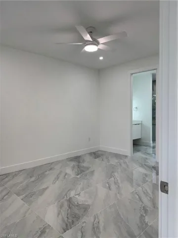 Unfurnished room with a ceiling fan, light marble finish flooring, and recessed lighting