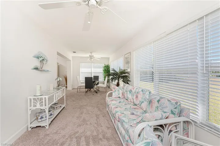 Carpeted living room featuring ceiling fan