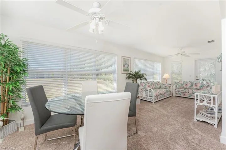 Carpeted dining area with ceiling fan