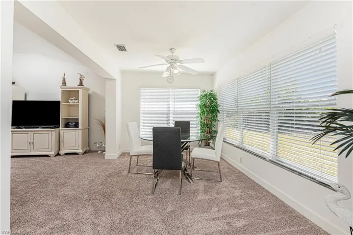 Carpeted dining space with ceiling fan