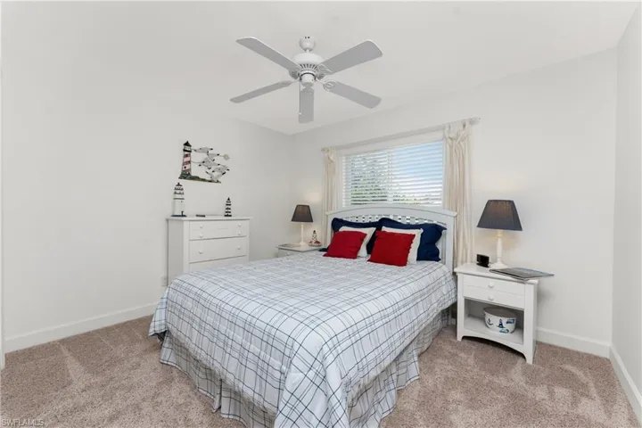 Carpeted bedroom featuring ceiling fan