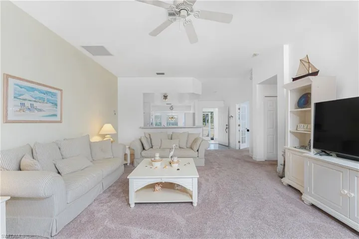 Living room featuring ceiling fan and light colored carpet