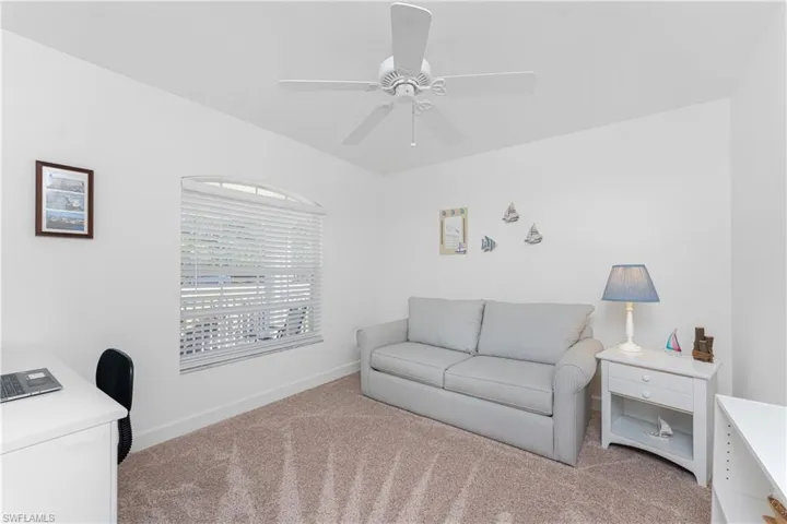 Carpeted living room featuring ceiling fan