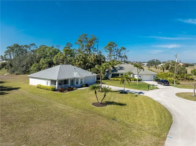 Ranch-style home featuring a garage and a front lawn