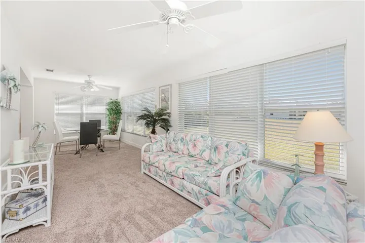 Carpeted living room with ceiling fan