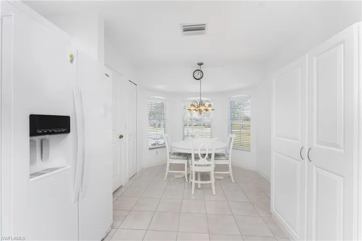 Dining space with light tile patterned floors and an inviting chandelier