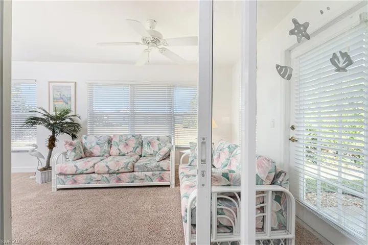 Carpeted living room featuring ceiling fan