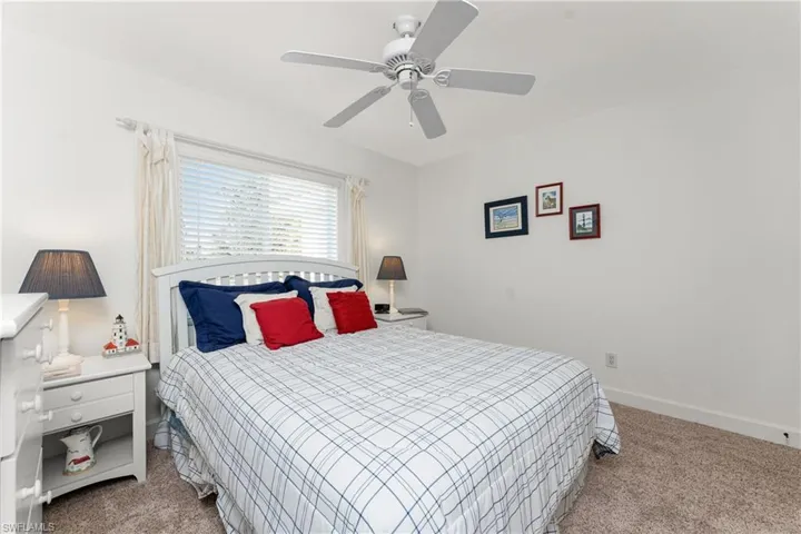 Carpeted bedroom featuring ceiling fan