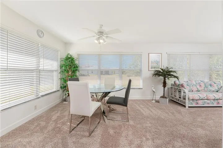 Dining space featuring light colored carpet and ceiling fan