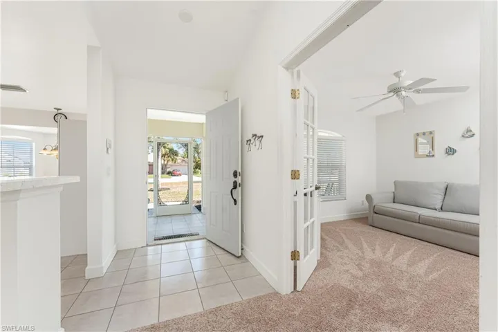 Carpeted foyer entrance featuring ceiling fan