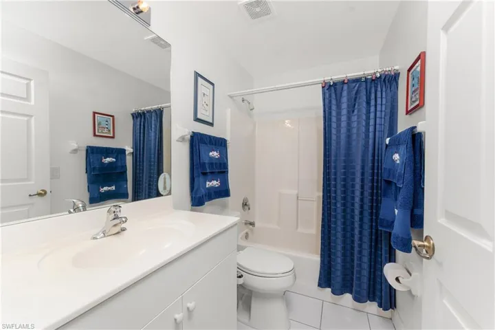 Full bathroom featuring shower / tub combo, vanity, tile patterned flooring, and toilet