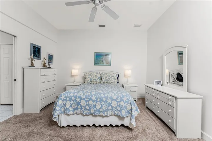 Carpeted bedroom featuring ceiling fan