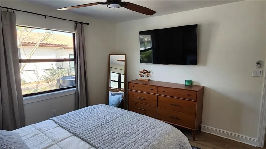 Bedroom featuring a large window, ceiling fan, and LVP floors