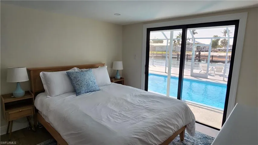 Den staged as a bedroom featuring pool access