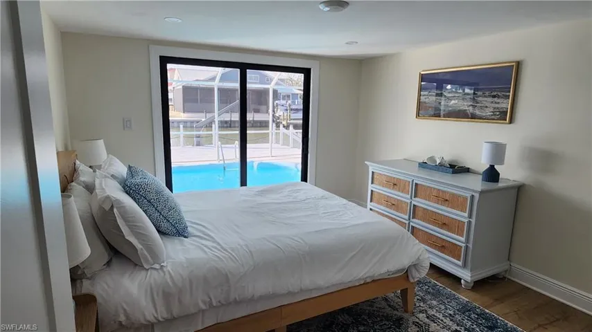 Den staged as a bedroom featuring LVP flooring and access to outside