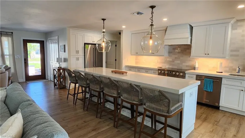 Kitchen featuring a large center island, premium range hood, and high end appliances