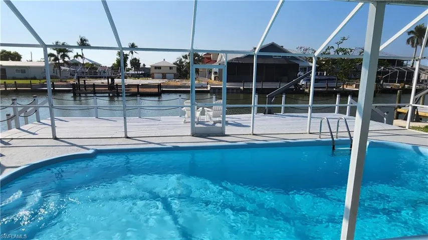 View of pool featuring a lanai and a dock