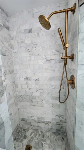 Bathroom featuring marble tiled shower