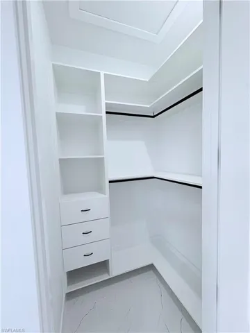 Walk in closet with light marble finish floors